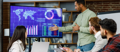 AI development company team analyzing AI-driven business analytics dashboard with global data insights