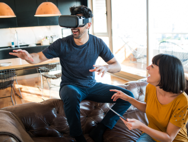 AI Solutions for Entertainment Man enjoying virtual reality experience in living room with companion nearby